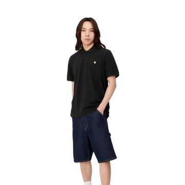 Modelo con el polo Carhartt WIP S/S Chase Pique negro con el logo bordado en dorado