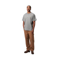 Carhartt WIP Chase T-Shirt gris jaspeado, vista frontal completa sobre modelo, logo bordado dorado en el pecho izquierdo, combinada con pantalón cargo marrón.
