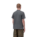 Carhartt WIP S/S Chase T-Shirt en color styx con detalle dorado, vista trasera sobre modelo masculino. Camiseta de algodón peinado de manga corta en gris pizarra oscuro con cuello redondo y espalda lisa sin estampados. Corte loose fit.