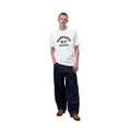 Carhartt WIP S/S Column T-Shirt en color blanco, vista completa de look sobre modelo masculino. Camiseta de algodón orgánico con estampado tipográfico en negro en el pecho con el texto 