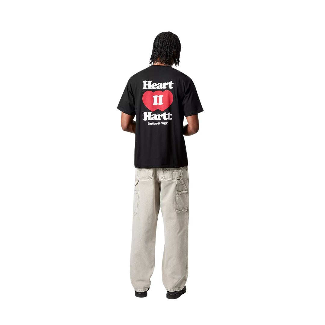 Modelo vistiendo la camiseta negra Carhartt WIP S/S Heart II Hartt T-Shirt en vista trasera de cuerpo entero