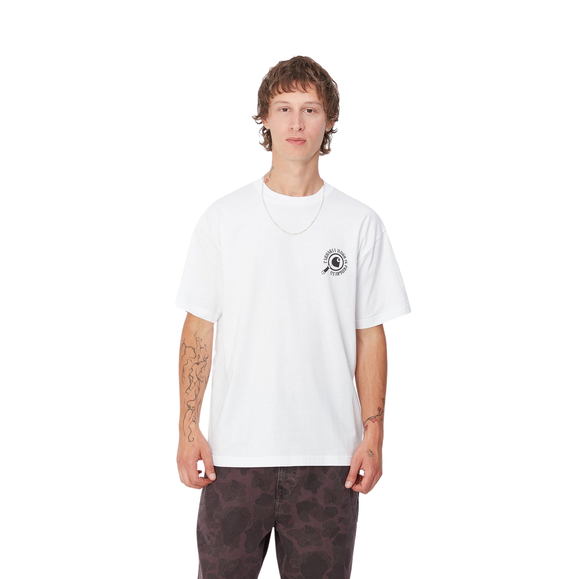 Hombre con la camiseta de manga corta Carhartt WIP S/S Inspector T-Shirt Blanca con una lupa y la leyenda "Carhartt Wor in Progress" estampados en el pecho