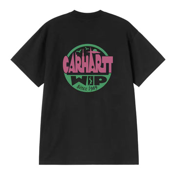 Carhartt WIP S/S Luggage Label T-Shirt negra, vista trasera: gran insignia circular con skyline urbano, logo Carhartt WIP y texto Since 1989 en rosa y verde, corte oversized.