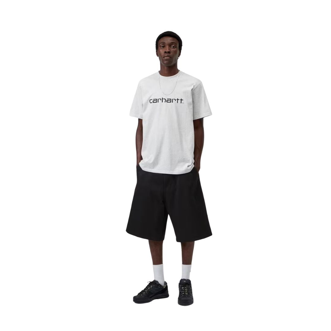 Hombre con la Camiseta de manga corta Carhartt Script Gris ceniza con el logo en Grafito en el pecho y pantalones negros.