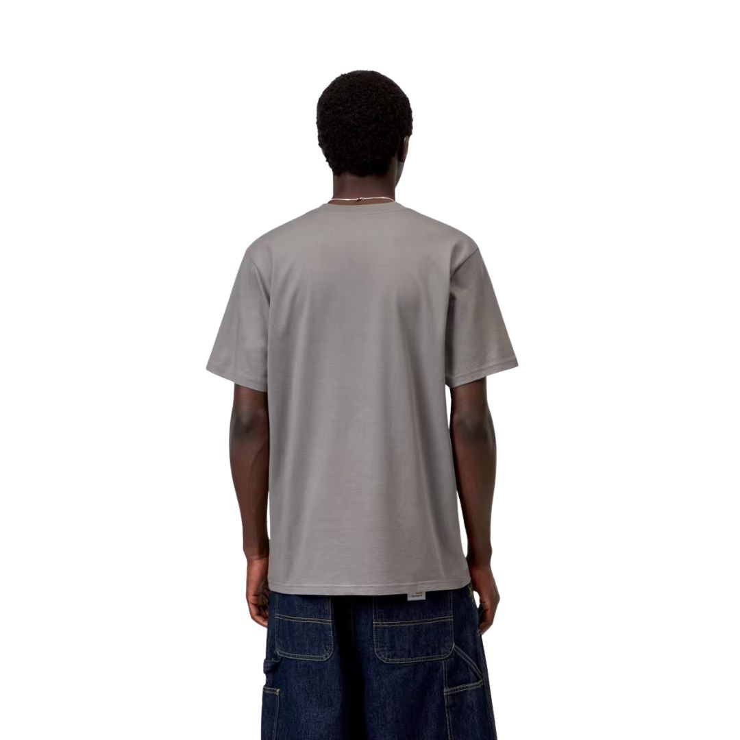 Modelo luciendo de espaldas la camiseta Carhartt WIP S/S Script T-Shirt en color Shady Grey. Se aprecia el corte holgado y la caída de la prenda en punto de algodón sin estampado.