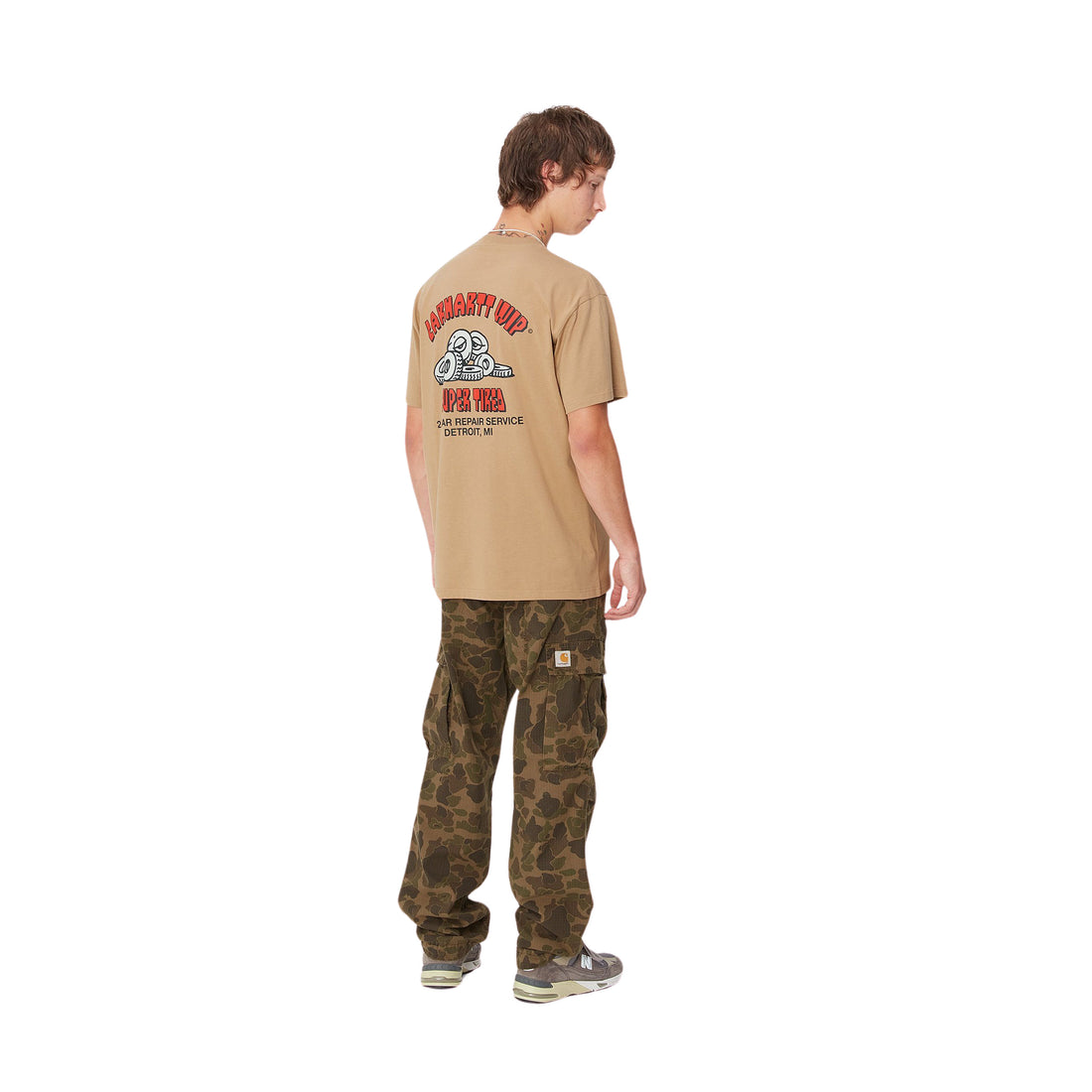 Hombre con la camiseta de manga corta Carhartt WIP S/S Super Tired T-Shirt Peanut con unas ruedas cansadas y la leyenda "Super Tired" estampadas en la espalda