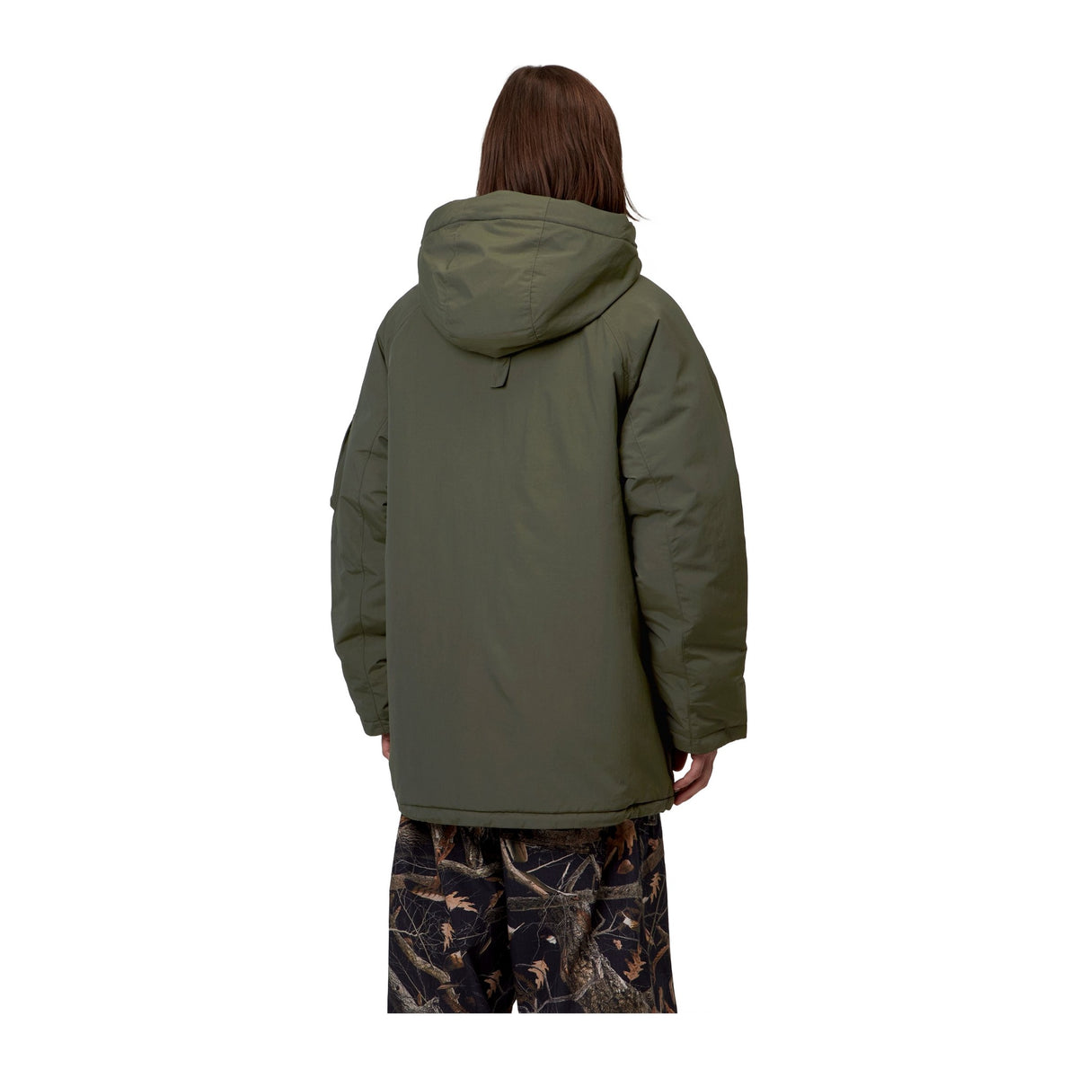 Vista trasera de modelo con la parka Carhartt WIP Stanwood Parka en color Cypress, mostrando la capucha y el largo de la prenda por debajo de la cadera.