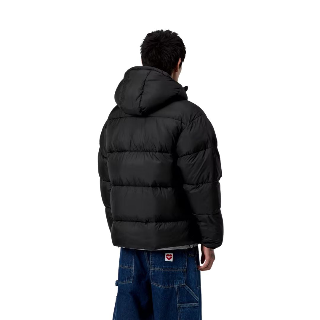 Modelo masculino vistiendo chaqueta Carhartt WIP Toronto Jacket color Black Camo Duck Green cerrada con capucha puesta.