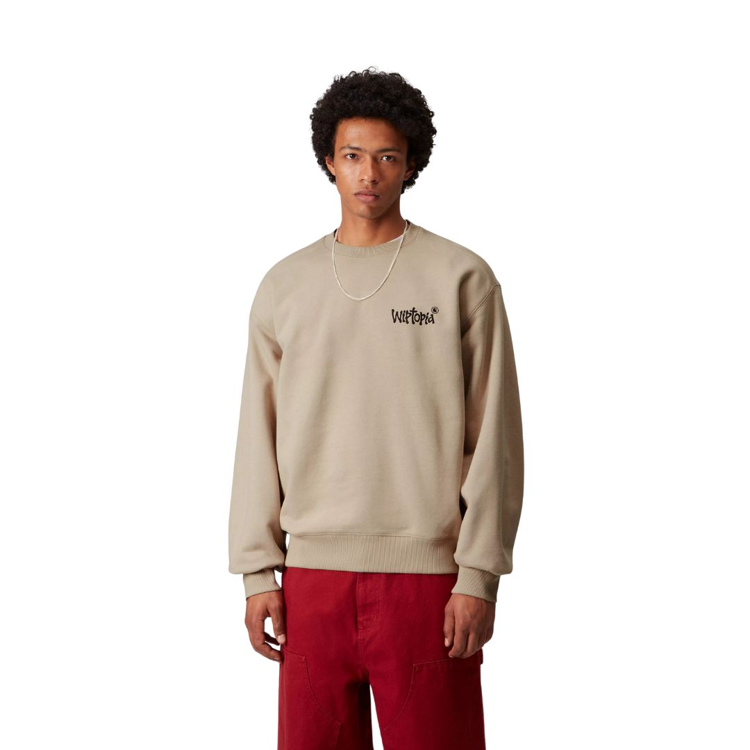 Carhartt WIP Wiptopia Sweatshirt color Wall en modelo, sudadera beige oversize con logo gráfico en el pecho.