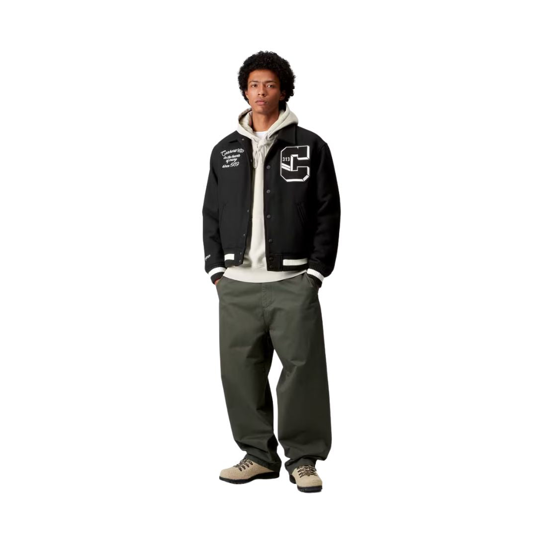 Modelo vistiendo la chaqueta Carhartt WIP World Class Varsity color Black vista frontal de cuerpo entero.