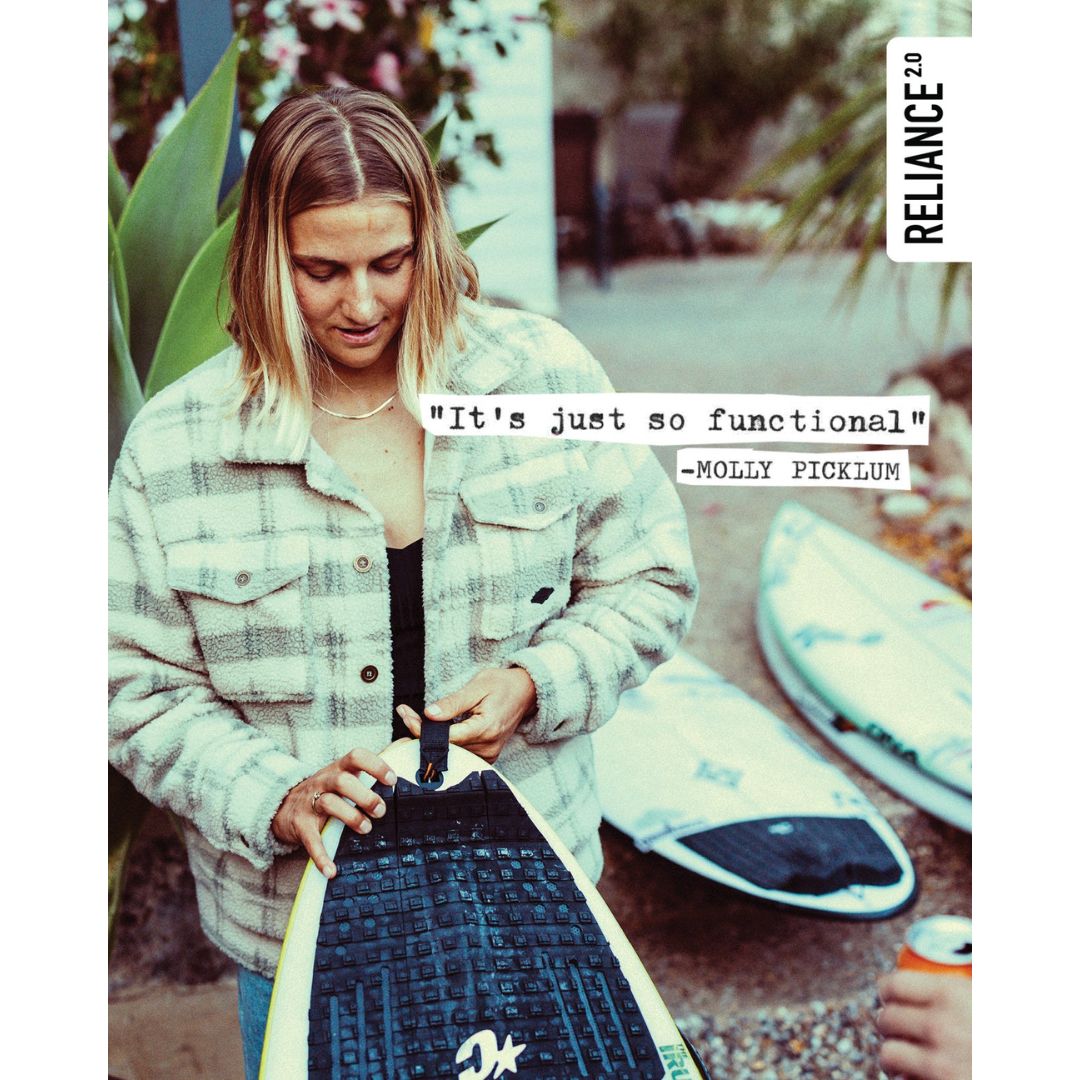 Surfista enganchando el leash Creatures of Leisure Reliance 2.0 Medium Duty 6' en color hi-vis purple twist black al leash plug de su shortboard.