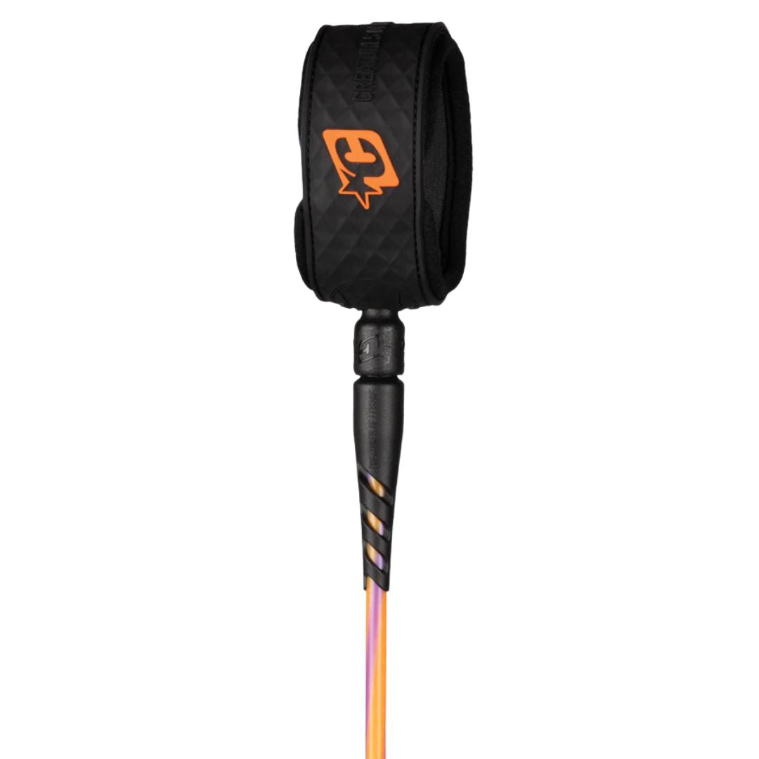 Leash de surf Creatures of Leisure Reliance 2.0 Standard Duty 6' hi-vis purple twist black con tobillera negra, logo naranja, doble swivel marino negro y cordón naranja y morado de 7 mm.