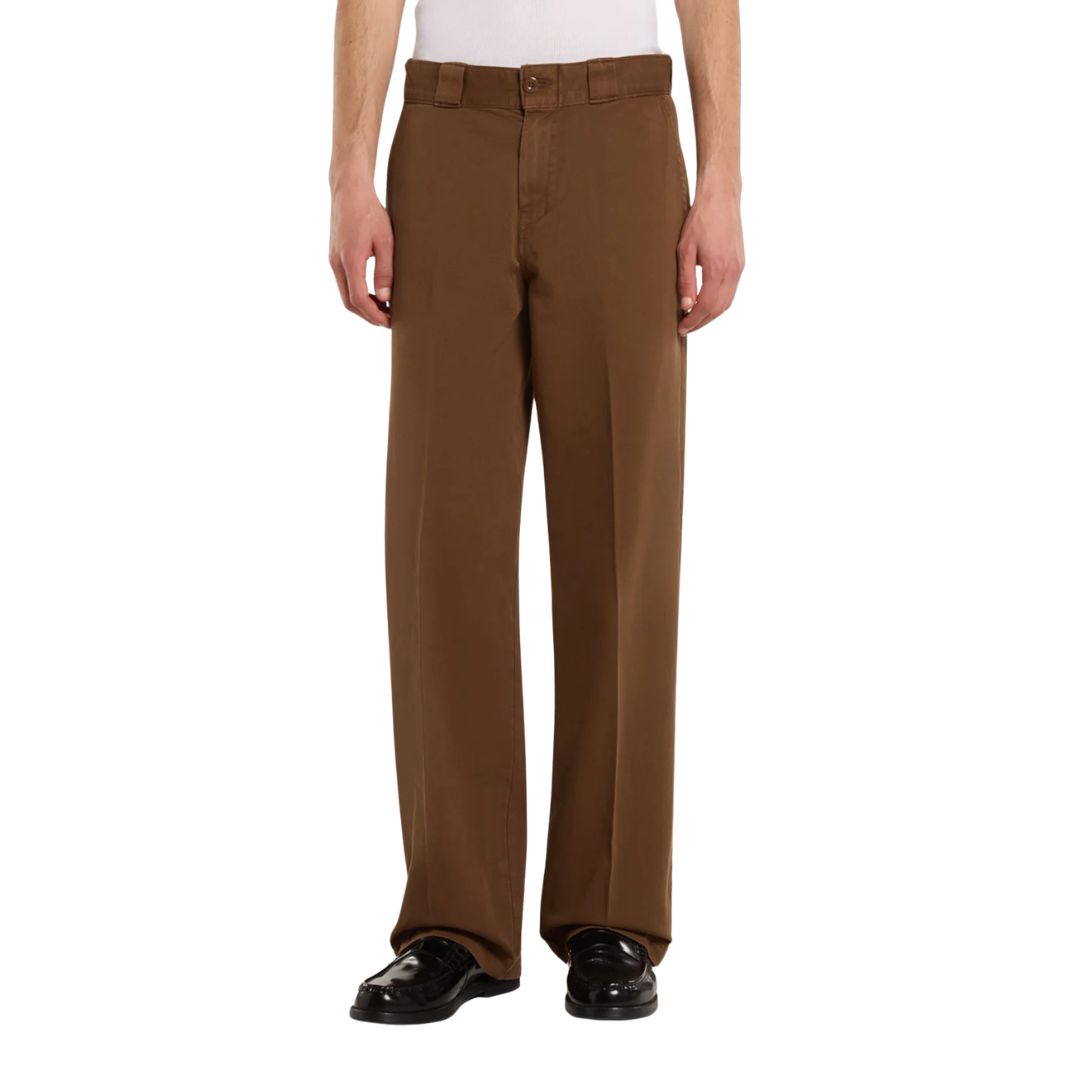 Vista frontal del pantalón Dickies 247 Loose GD en marrón Timber sobre modelo, con la pretina alta, el cierre de botón y la caída recta característica del corte holgado.