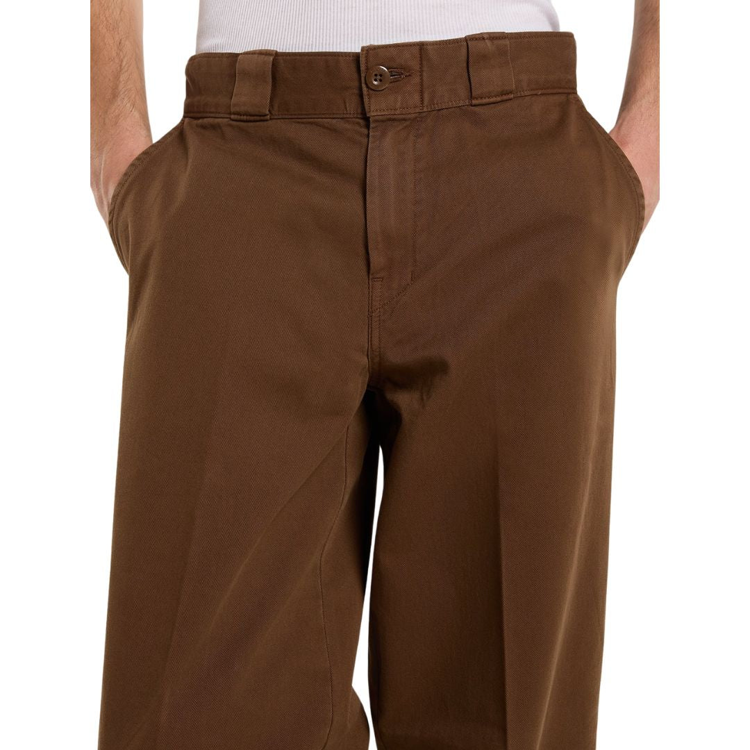 Primer plano de la cintura del pantalón Dickies 247 Loose GD en marrón Timber: cierre frontal con botón, trabillas anchas y acabado en sarga de algodón con tacto afelpado.