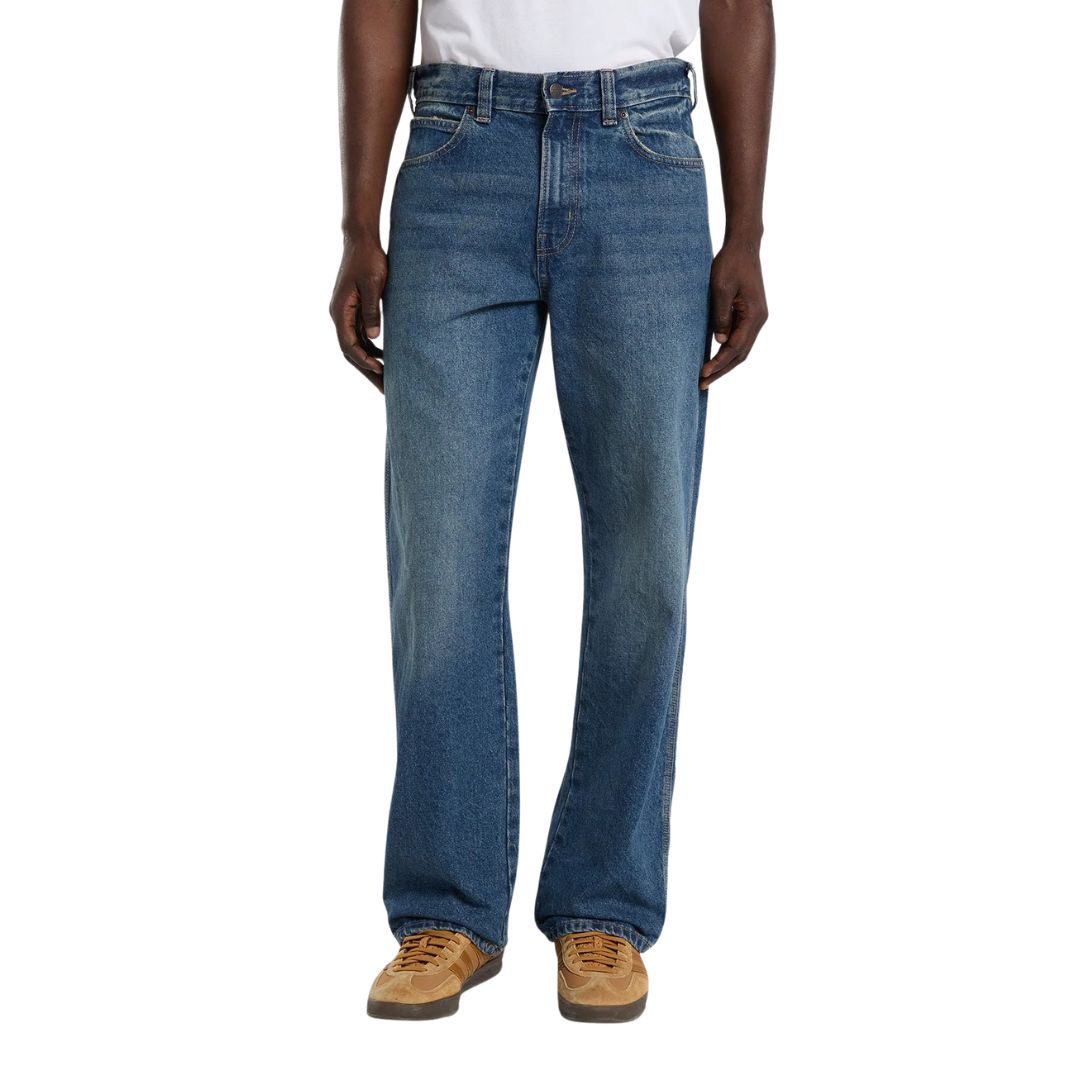 Vista frontal de modelo con vaqueros Dickies 954 Relaxed Straight Work Jeans classic blue de pierna recta y corte relaxed, con botón metálico, cinco bolsillos y zapatillas.