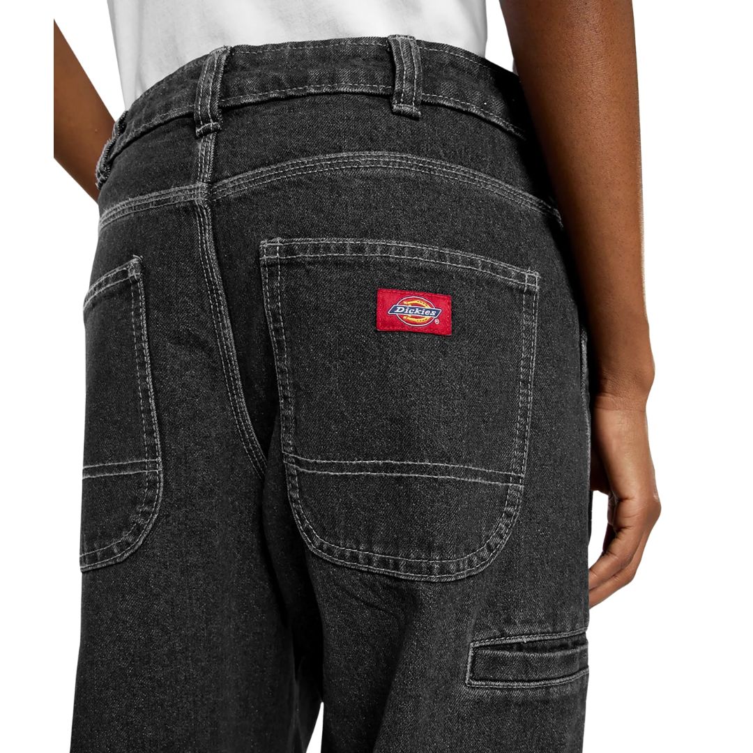 Detalle bolsillos traseros Dickies 958 Baggy Tapered Work Jeans Black Washed Fade con etiqueta roja Dickies y tejido denim lavado efecto desgastado.
