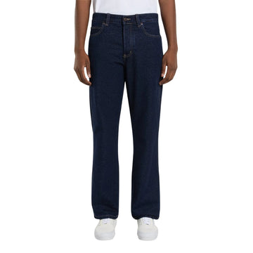 Vista frontal de modelo con vaqueros Dickies 983 Regular Straight Jeans rinsed de pierna recta, con botón metálico, cinco bolsillos, costuras vistas en contraste y zapatillas blancas.