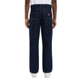 Vista trasera de modelo con vaqueros Dickies 983 Regular Straight Jeans rinsed, con dos bolsillos traseros en punta con doble costura, etiqueta roja Dickies y zapatillas blancas.