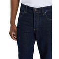 Detalle de la cintura de los vaqueros Dickies 983 Regular Straight Jeans rinsed sobre modelo, con botón metálico, remaches, trabillas de cinturón y bolsillo delantero con costuras.