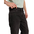 Detalle frontal de la cintura y del bolsillo delantero de los vaqueros Dickies 993 Regular Tapered Carpenter black, con remaches metálicos y un modelo tirando de la cintura.