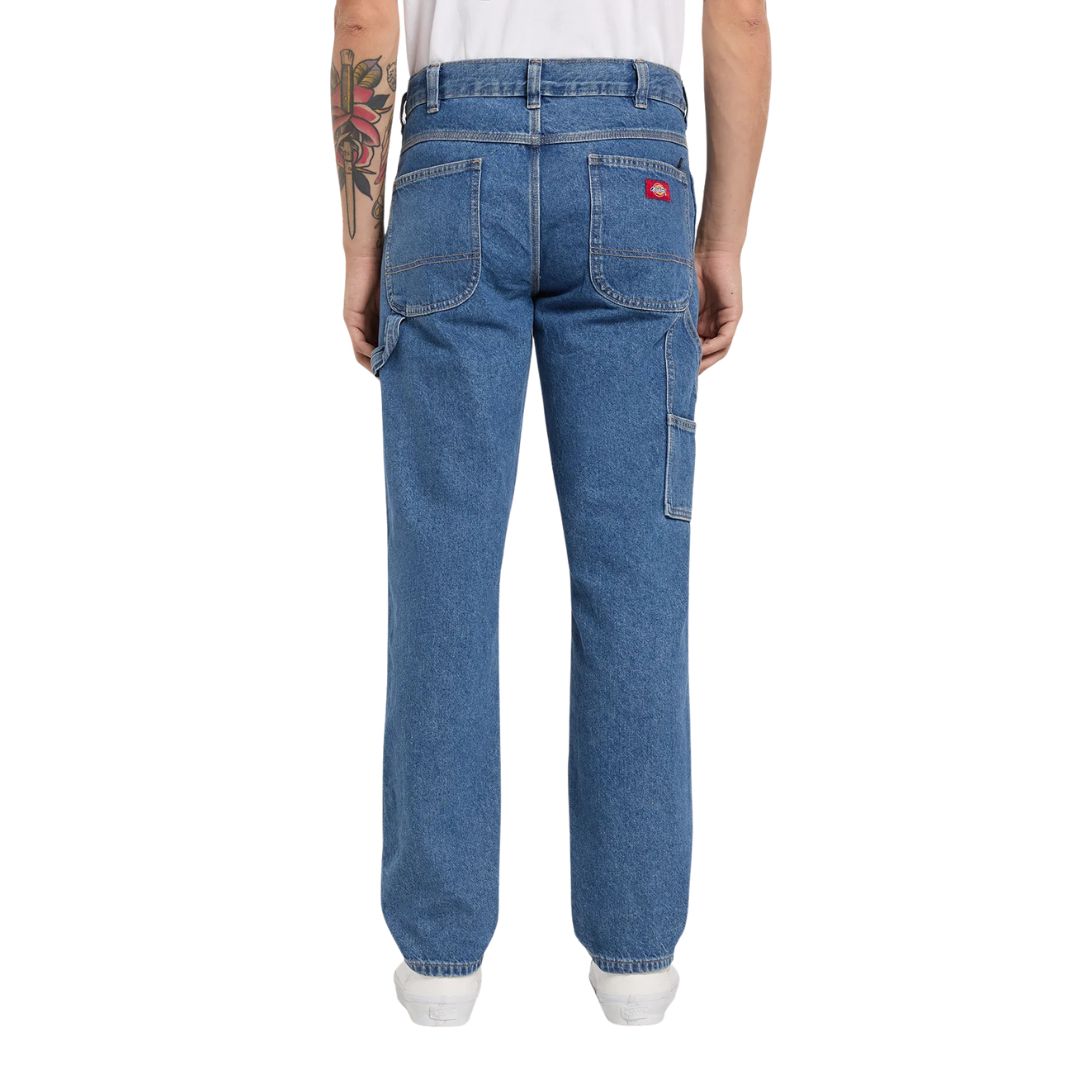Vista trasera con modelo de los pantalones Dickies 993 Regular Tapered Carpenter en color classic blue.