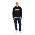 Look completo con vaqueros Dickies 993 Regular Tapered Carpenter dark indigo de corte recto, combinados con sudadera con capucha de logo Dickies y zapatillas blancas.