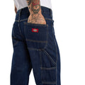 Primer plano del bolsillo trasero con etiqueta roja Dickies y del bolsillo utilitario de los vaqueros 993 Regular Tapered Carpenter dark indigo, con costuras en contraste.