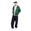 Modelo vistiendo sudadera Dickies Bolivar FZ Hoodie color Pine Needle Green con cremallera y capucha - look completo.