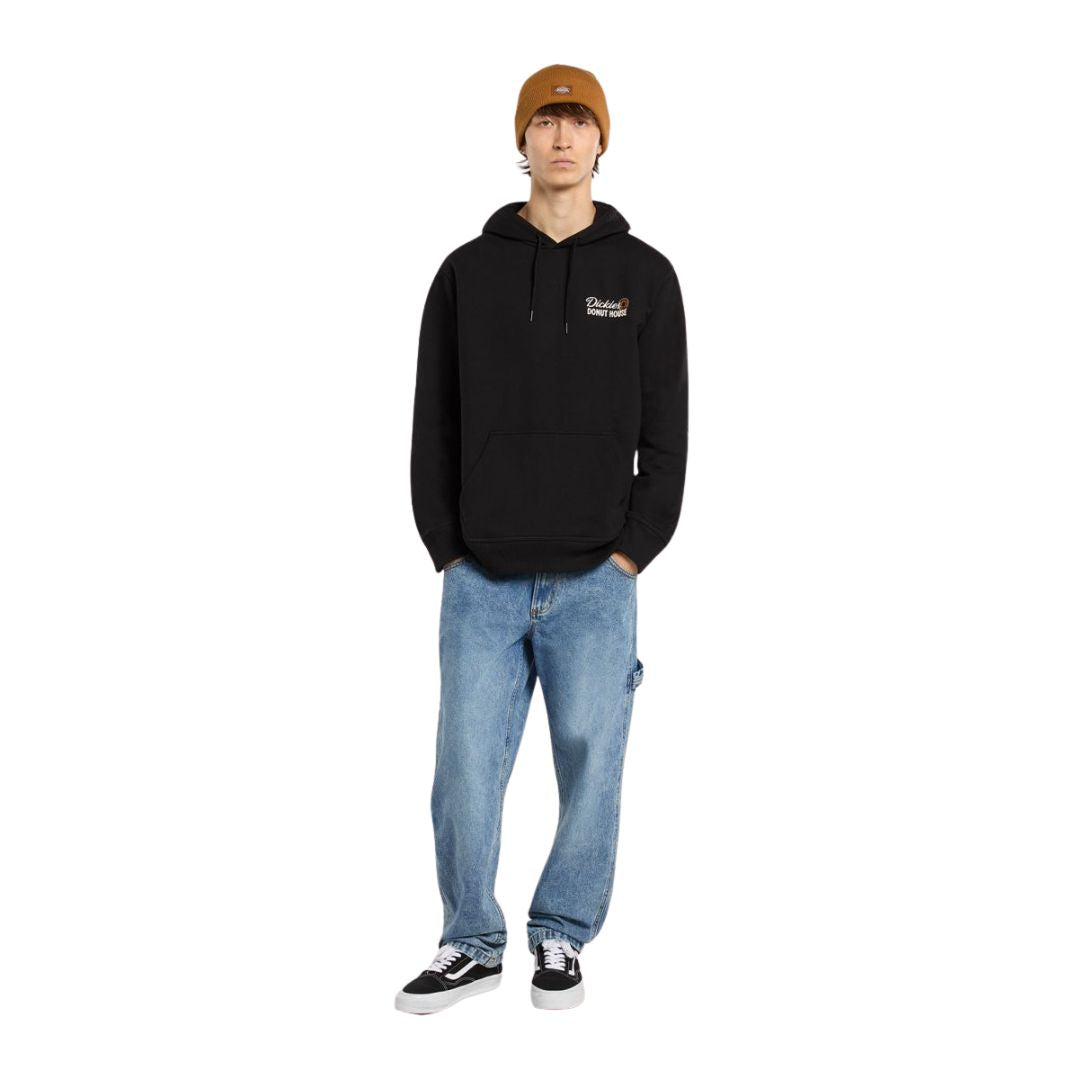 Modelo con sudadera Dickies Donut House Hoodie negra, look urbano con vaqueros y gorro.
