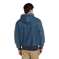 Modelo de espaldas con la Dickies Hilham LN DNM Hood Bomber, bomber de denim azul lavado con capucha, costuras marcadas en hombros y mangas y bajo acanalado azul marino.