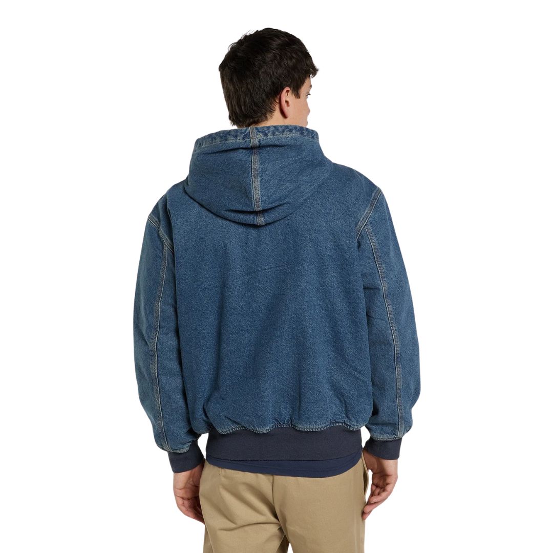 Modelo de espaldas con la Dickies Hilham LN DNM Hood Bomber, bomber de denim azul lavado con capucha, costuras marcadas en hombros y mangas y bajo acanalado azul marino.