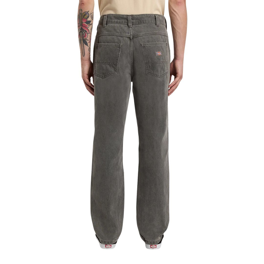 Vista trasera del modelo vistiendo el pantalón Dickies Houston Denim Grey Wash Tinted gris lavado, mostrando ajuste recto.