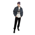Modelo con la Dickies McDermitt SS Tee blanca crudo abierta bajo una camisa de cuadros azul, con gorro morado, pantalón negro y botas negras de caña alta.