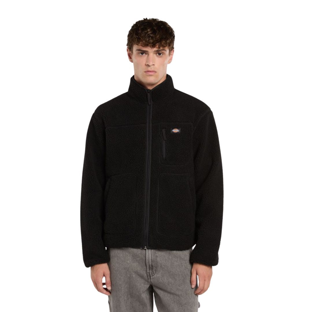 Modelo de frente luciendo el forro polar Dickies Mount Hope Fleece color Black con cremallera subida y cuello alto.