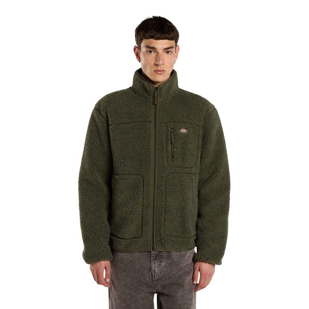 Modelo de frente con la Dickies Mount Hope Fleece verde oliva con cremallera cerrada, cuello alto, bolsillo de pecho con etiqueta Dickies y dos bolsillos frontales grandes.