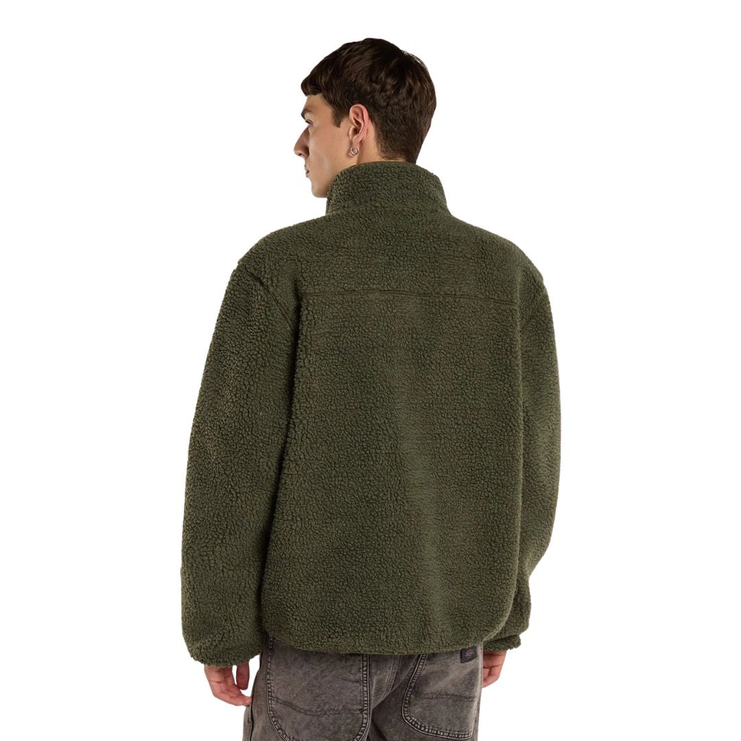 Modelo de espaldas con la Dickies Mount Hope Fleece, chaqueta de forro polar popcorn verde oliva con cuello alto y costura de canesú, sobre vaqueros grises lavados.
