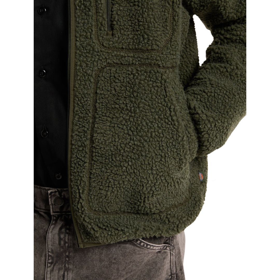 Detalle de los bolsillos con costuras vistas de la Dickies Mount Hope Fleece de forro polar popcorn verde oliva, con la cremallera del bolsillo de pecho y etiqueta tejida en el lateral.