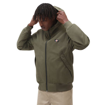 Modelo ajustando la capucha de la chaqueta Dickies New Sarpy verde militar, tejido resistente al agua.