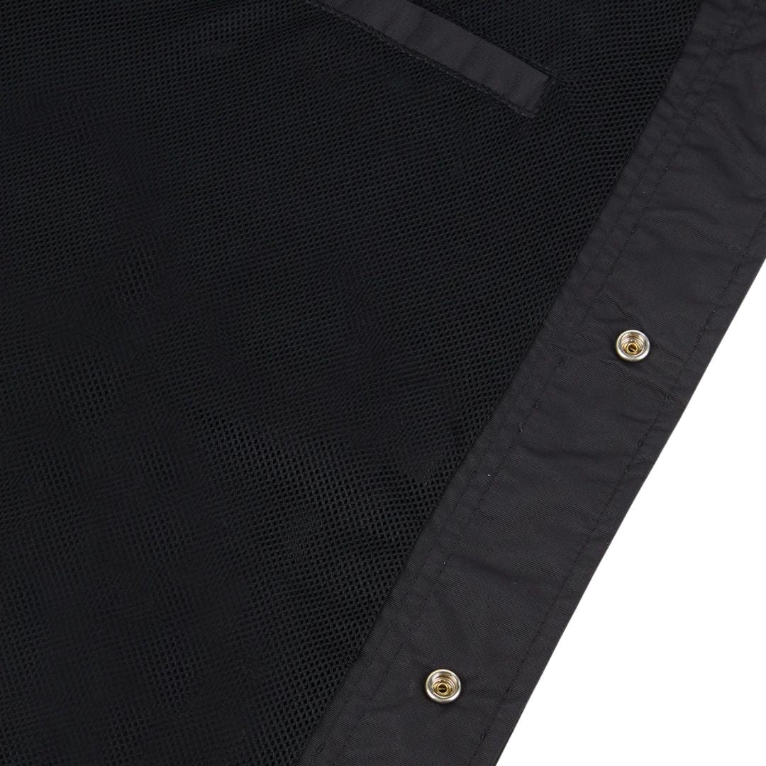Detalle interior de la chaqueta Dickies Oakport Coach Jacket negra con forro de malla y cierre de botones a presión.