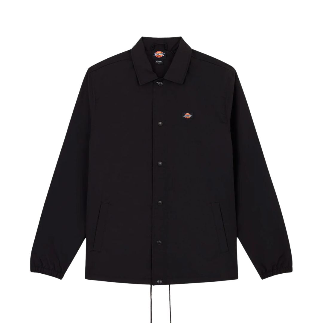 Chaqueta Dickies Oakport Coach Jacket negra colgada, vista frontal completa con cuello clásico y botones a presión.