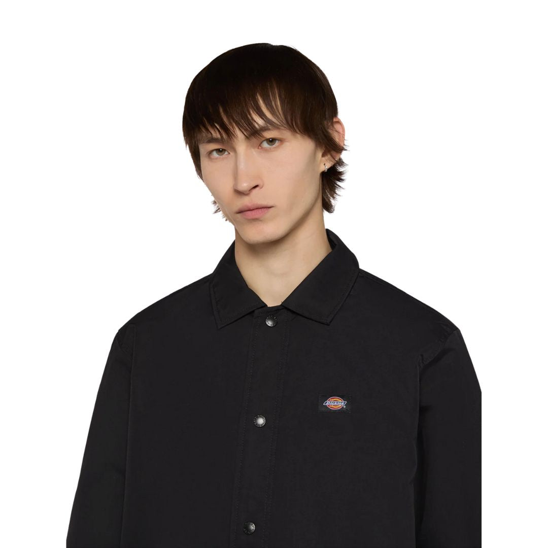 Primer plano del cuello clásico y cierre de botones de la chaqueta Dickies Oakport Coach Jacket negra.