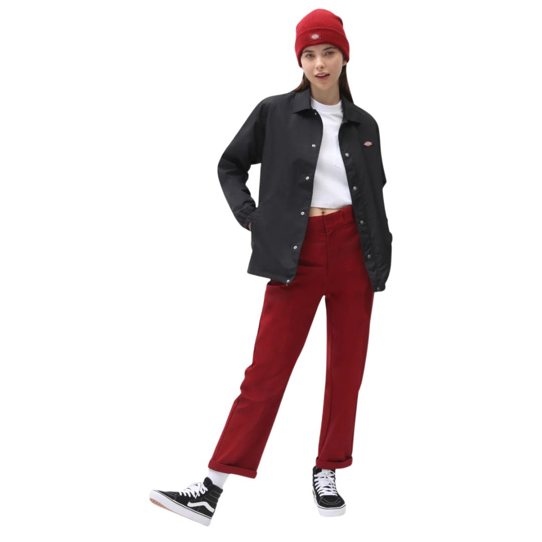 Modelo femenino llevando la chaqueta Dickies Oakport Coach Jacket negra en look urbano casual.