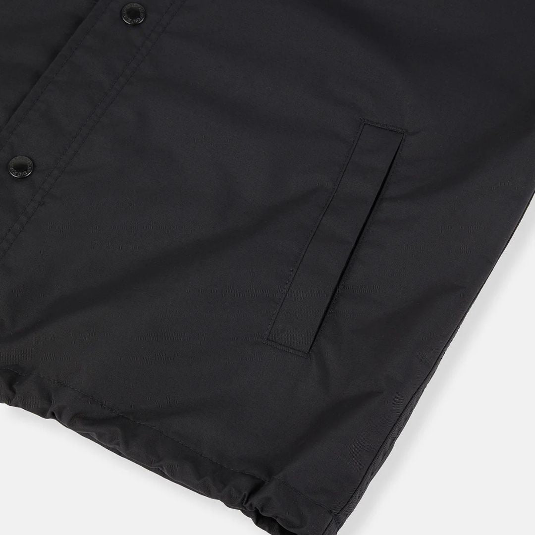 Detalle del tejido impermeable de la chaqueta Dickies Oakport Coach Jacket negra con bolsillo ribeteado.