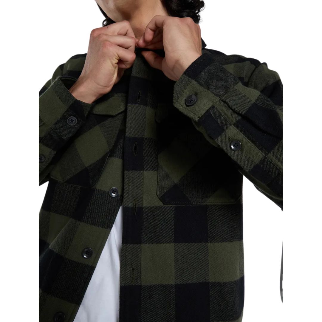Detalle del cuello de la Dickies Sacramento Shirt, camisa de franela a cuadros verde oliva y negro de algodón, con la mano abrochando el botón del cuello.