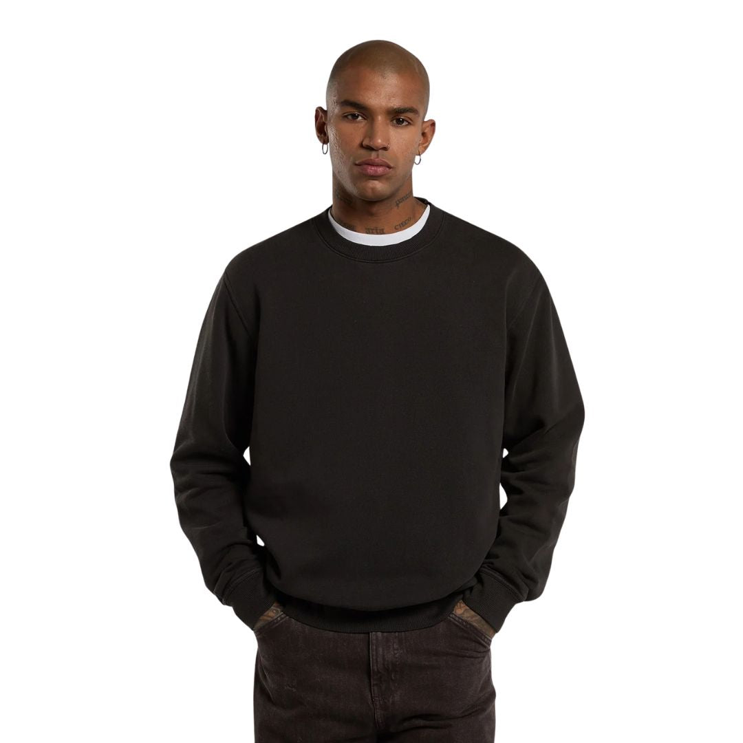 Modelo de frente con la Dickies Sutcliffe Sweatshirt marrón oscuro, mostrando el cuello redondo acanalado y las manos en los bolsillos del pantalón.