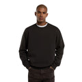 Modelo de frente con la Dickies Sutcliffe Sweatshirt marrón oscuro, mostrando el cuello redondo acanalado y las manos en los bolsillos del pantalón.