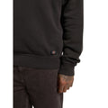 Detalle del bajo y el puño acanalados de la Dickies Sutcliffe Sweatshirt marrón oscuro, con la etiqueta Dickies cosida, sobre un pantalón marrón oscuro.