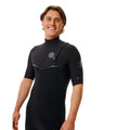 Vista frontal superior del traje Rip Curl E-Bomb 2/2 negro sin cremallera, con bolsillo exterior para llaves en pecho, logo E-Bomb en manga y cuello alto de neopreno sellado.