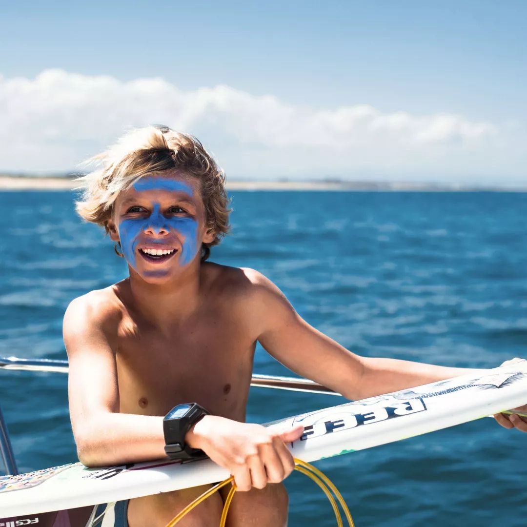 Niño surfista con protector solar EQ SPF50+ bio color blue aplicado en el rostro con protección solar resistente al agua.
