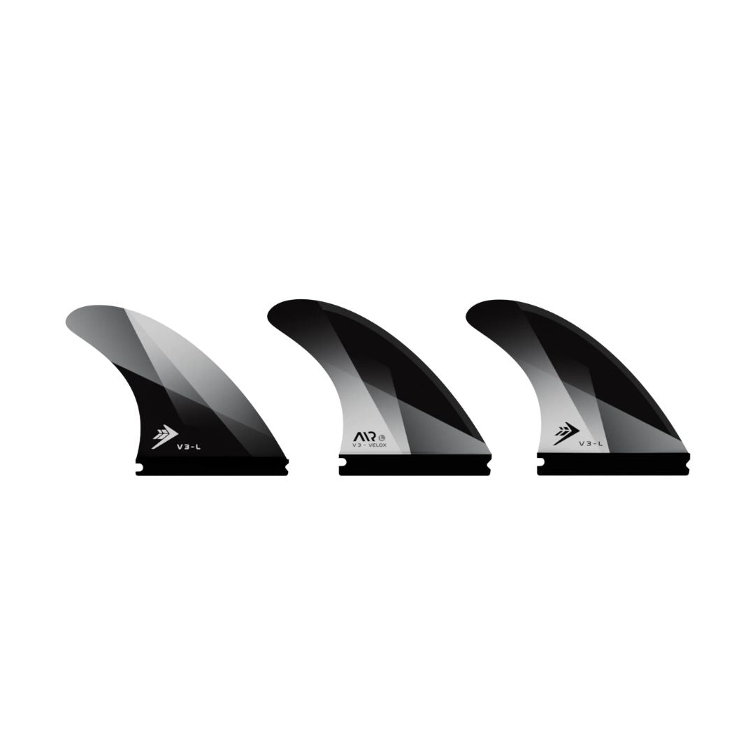 Detalle de las 3 quillas Firewire Velox talla Medium en acabado negro con acento blanco, mostrando el degradado de color en la punta de cada unidad.
